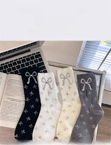 Detail of four-color knit socks with bow prints and rhinestone bow charms on cuffs