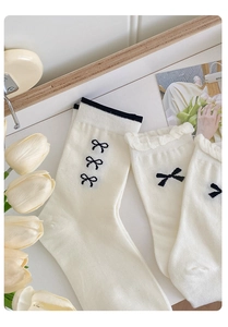 Detail weißer Baumwollsocken mit schwarzem Ripprand und süßen Schleifen-Akzenten