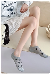 Close-up of knit cotton low cut socks with delicate black bow patterns and ribbed cuffs
