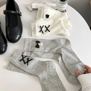 Japanese style mid-tube cotton socks with bows and pearls displayed with shoes