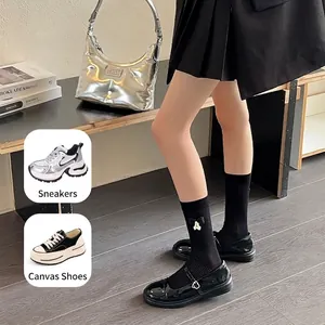 Ribbed black mid-calf cotton socks with white bow accents in stylish JK school style