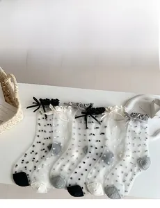 Detail von fünf Paar transparenten Tüllsocken mit Punkten und Schleifenverzierung