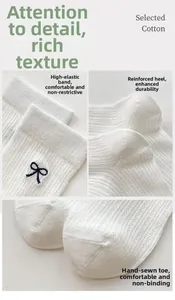 Detail of white cotton socks featuring navy bow embroidery and ribbed mesh texture