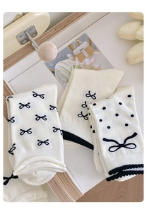 Detailansicht weißer Baumwollsocken mit schwarzen Schleifen und Spitzenverzierung für Damen