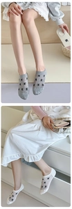 Detail of low-cut cotton invisible socks with black bow patterns in grey and white
