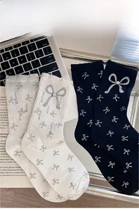 Detail of knit socks with bow embroidery and large gray bow featuring a sparkling rhinestone