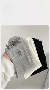 Detail of selected cotton crew socks with embroidery and ruffle cuffs in neutral colors