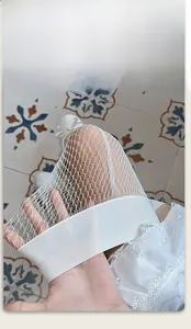 Détail du bord élastique sur les bas blancs en dentelle montrant l'élasticité et la maille