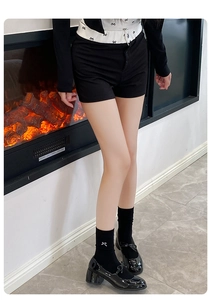 Detail of black knee-high socks with white bows paired with glossy Mary Jane platform shoes