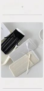 Détail de chaussettes en résille respirantes avec nœuds en noir, blanc et beige