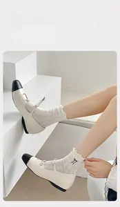 Detail of white ruffle socks with black bow embroidery and Selected Cotton texture