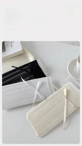Détail de chaussettes en coton à maille ajourée avec nœuds en blanc et beige