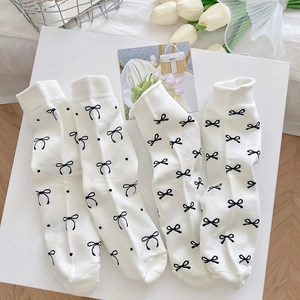 Weiße Baumwollsocken mit schwarzen Schleifen und Punkten in nordischem Design-Stil