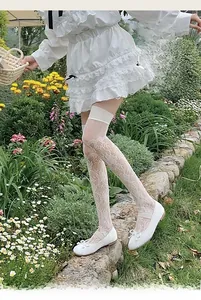 Gros plan sur des bas hauts en dentelle florale blanche avec larges poignets élastiques