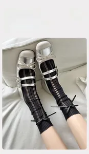 Détail de chaussettes en dentelle à nœud et babies argentées avec boucles en strass