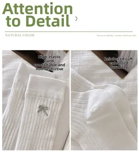Detail of white ribbed calf socks featuring gray bow embroidery and reinforced elastic cuffs