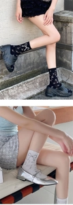 Detail of knit crew socks with bow jacquard pattern and textured dotted design