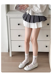 Detail of white striped calf socks featuring black bow embroidery and mesh hollow texture