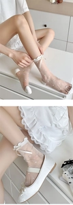 Detail von weißen Netzsocken mit süßer Schleife und strukturierten Punkten