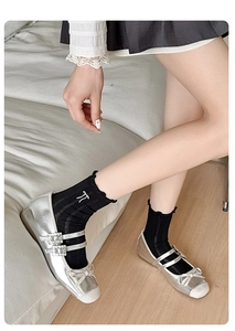 Silver metallic Mary Jane flats with bow detail and rhinestone buckles on a model