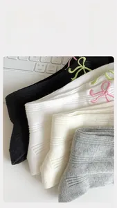Détail de chaussettes côtelées avec nœud brodé offrant une élasticité de 200% et un bon maintien