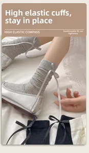 Detail of balletcore ribbed socks with silk bows paired with silver ballet flats