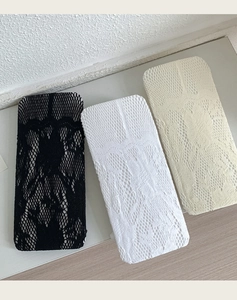 Détail de la texture en dentelle des bas autofixants en noir, blanc et beige