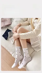 Detailed view of polka dot cotton socks with ribbed cuffs on female model feet