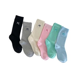 Six pairs of solid color mid-calf cotton socks with delicate bow embroidery in pastel tones