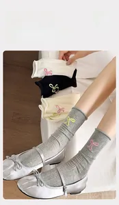 Détail de chaussettes en coton avec broderie nœud délicate et maille côtelée