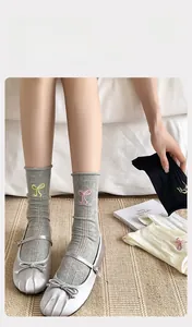 Détail de chaussettes en coton doux avec broderie nœud et texture côtelée verticale
