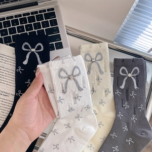 Distressed knit socks featuring silver bow prints and rhinestone accents in various colors