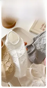 Close-up of pure cotton no-show socks featuring embroidered smiley faces in multiple colors