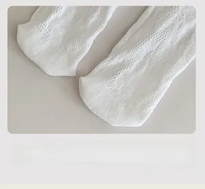 Détail de chaussettes hautes blanches en dentelle ajourée avec couture lisse aux orteils