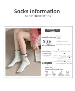 Detail of white crew socks featuring scalloped edges and black butterfly embroidery accents