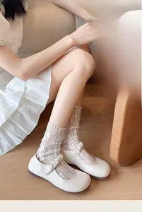 Detailed close-up of white floral lace socks paired with vintage white Mary Jane shoes