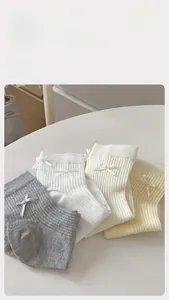Details von weißen Baumwollsocken mit zarten Schleifen und gerippter Strickstruktur