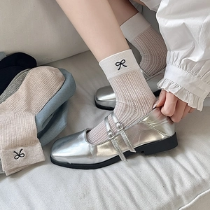 Mesh socks with black bow embroidery paired with silver metallic Mary Jane shoes