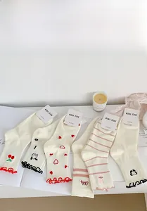 Close-up of cotton crew socks set featuring cute cartoon embroidery and ruffled edges