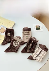 Détail de cinq paires de chaussettes vintage en coton marron avec broderie ours et rayures
