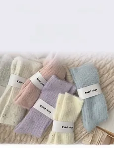Close-up of pastel fleece socks in multiple colors with soft plush texture on knit surface