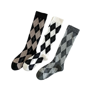 Three pairs of argyle calf socks in black, white, and grey color-block patterns