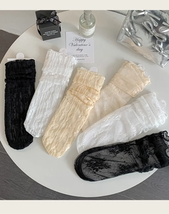 Detail of floral lace hollow socks with ruffled edges in black white and beige colors