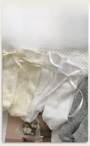 Detailed view of ribbed cotton mid-calf socks with silky satin bows in white and grey