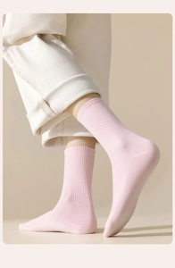 Detail von hellrosa gerippten Baumwollsocken mit weicher Strickstruktur und elastischen Bündchen