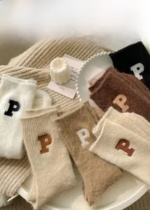 Detail of assorted warm winter wool socks with P-letter embroidery on knit fabric