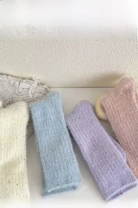 Detailed texture of thick macaron fleece socks in cream yellow, blue, and purple tones