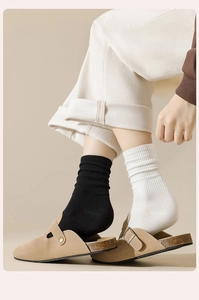 Detail von gerippten Baumwollsocken kombiniert mit stylischen Wildleder-Clogs