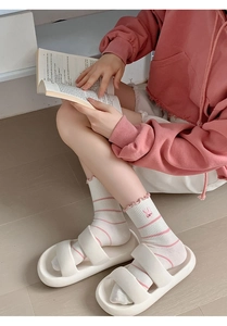 Close-up of white crew socks with pink stripes, ruffle trim, and cute rabbit embroidery