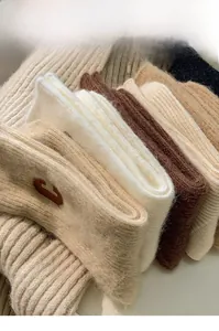 Close-up of thick wool socks with ribbed texture and embroidered C letter detail